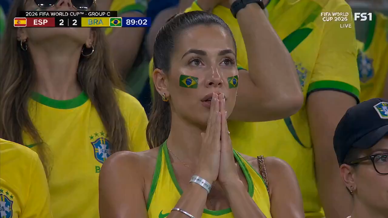 A passionate Brazilian female football fan in a yellow Brazil jersey, cheering enthusiastically in the packed stadium stands, her face painted green and yellow with the Brazilian flag, eyes wide with excitement as she waves a national flag, stadium floodlights casting dramatic golden light across her joyful expression, crowd roaring in the background