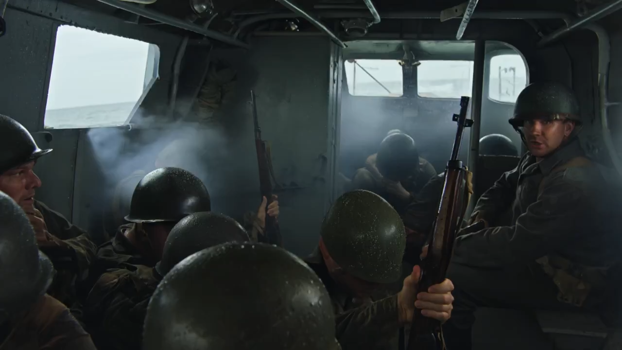 Young soldiers in weathered armor seated inside a war chariot, listening intently as a battle-hardened general stands before them delivering an impassioned speech, torchlight flickering across their determined faces, dust motes drifting through shafts of light, dramatic cinematic composition with deep shadows and golden highlights emphasizing the weight of the moment